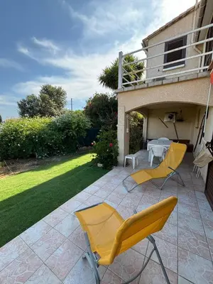 a patio with two yellow chairs and a table at Rez de villa de 45 m2 Afa calme et fleuri in Afa