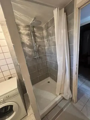 a shower in a bathroom with a shower curtain at Rez de villa de 45 m2 Afa calme et fleuri in Afa