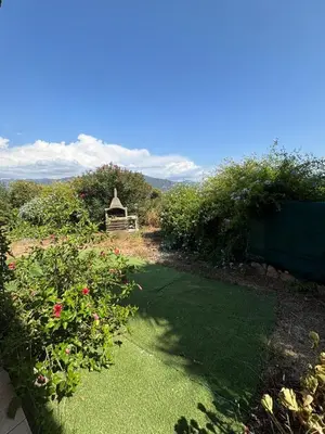 a garden with a gazebo and some bushes and grass at Rez de villa de 45 m2 Afa calme et fleuri in Afa