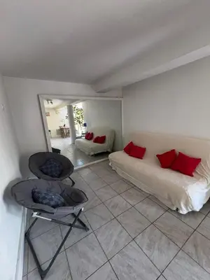 a bedroom with a bed and a chair in it at Rez de villa de 45 m2 Afa calme et fleuri in Afa