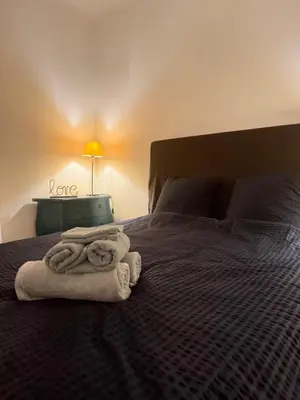 a bedroom with a bed with towels on it at Grand T2 Ajaccio - Proche port et transports in Ajaccio