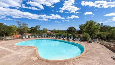a swimming pool with chairs and umbrellas at Lisa Maria D N38 2P5 in Sari Solenzara