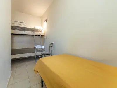 a room with a bed and a bunk bed with a ladder at Lisa Maria E N60 3P7 in Sari Solenzara