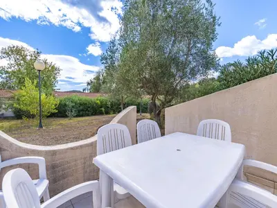 a white table and chairs on a patio at Lisa Maria E N60 3P7 in Sari Solenzara