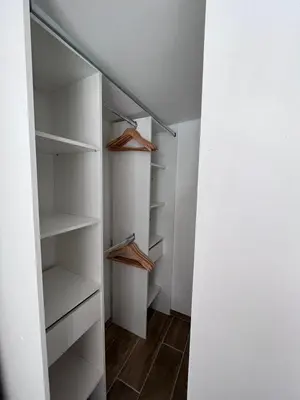 a walk in closet with white walls and wooden shelves at Belle villa avec piscine à Bonifacio in Bonifacio