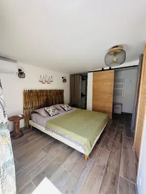 a bedroom with a bed with a wooden headboard at Belle villa avec piscine à Bonifacio in Bonifacio
