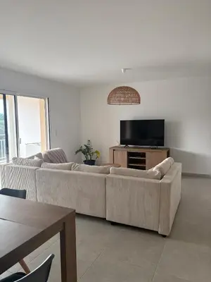 a living room with couches and a flat screen tv at T3 tout confort in Alata