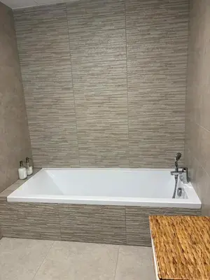 a bath tub with a sink in a bathroom at T3 tout confort in Alata