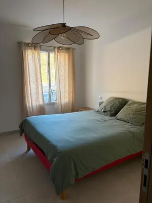 a bedroom with a bed and a ceiling fan at T3 tout confort in Alata