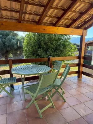 a patio with a table and chairs on a deck at Villa T3 avec piscine in Sollacaro