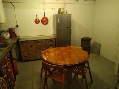 a kitchen with a wooden table and a refrigerator at Gîte nature sous les châtaigniers in Zonza