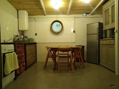 a kitchen with a table and chairs and a refrigerator at Gîte nature sous les châtaigniers in Zonza