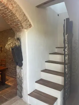 a staircase in a house with a stone wall at Casetta Teppe rosse in Aléria