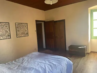 an empty bedroom with a bed and a window at Casetta Teppe rosse in Aléria