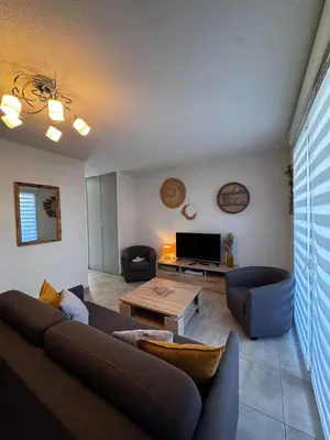 a living room with a couch and a table at Mini-villa with swimming pool in Bonifacio residence in Bonifacio