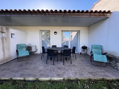 a patio with a table and chairs on it at Mini-villa with swimming pool in Bonifacio residence in Bonifacio