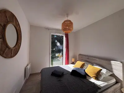 a bedroom with a bed with yellow pillows and a window at Mini-villa with swimming pool in Bonifacio residence in Bonifacio