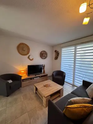 a living room with a couch and a tv at Mini-villa with swimming pool in Bonifacio residence in Bonifacio