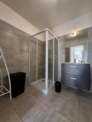 a bathroom with a shower with a glass door at Mini-villa with swimming pool in Bonifacio residence in Bonifacio