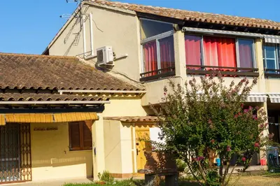 a house with red and white curtains on the windows at A nostra casetta corsa,Tania, en bord de mer in Ghisonaccia