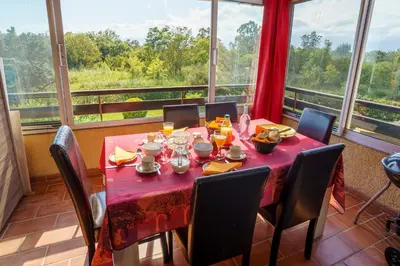 a dining room with a red table and chairs and a window at A nostra casetta corsa,Tania, en bord de mer in Ghisonaccia