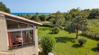 a person sitting in a window of a house at A nostra casetta corsa,Tania, en bord de mer in Ghisonaccia