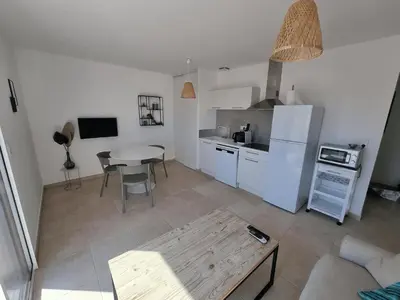 a kitchen with a table and a white refrigerator at Corsica Beach, Paddleboarding, Pool & Hiking J159 in Linguizzetta