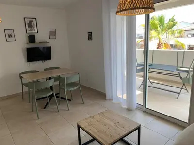 a living room with a dining room table and a television at Corsica Beach, Paddleboarding, Pool & Hiking J159 in Linguizzetta