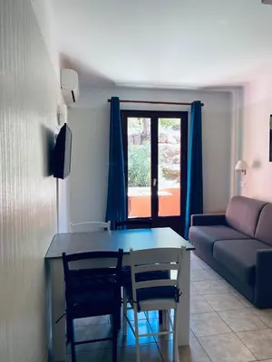 a living room with a table and a couch at Petit cocon près des Calanques de Piana in Porto Ota