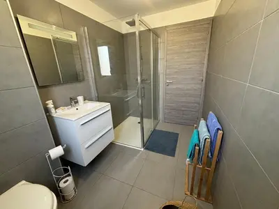 a bathroom with a shower and a sink and a toilet at Appartement sécurisé 100m du port de Porto Vecchio in Porto-Vecchio