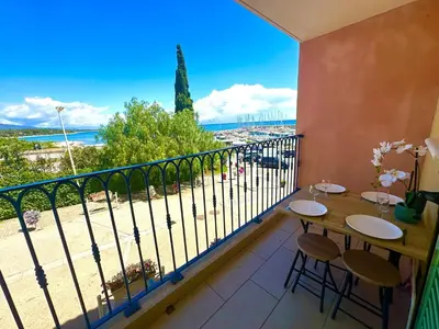 a balcony with a table and chairs and a view of the beach at Appartement pieds dans l'eau sur Port de Plaisance in Sari Solenzara