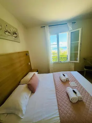 a bedroom with a bed with towels and a window at Appartement pieds dans l'eau sur Port de Plaisance in Sari Solenzara