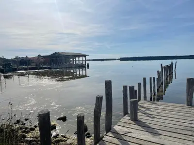 a dock on a lake with a house on it at Appartement pieds dans l'eau sur Port de Plaisance in Sari Solenzara
