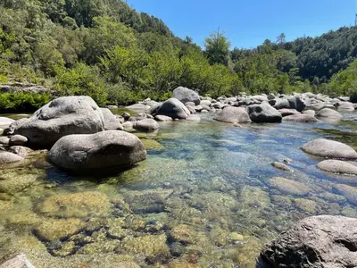 a river with large rocks in the water at Appartement pieds dans l'eau sur Port de Plaisance in Sari Solenzara