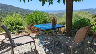 a blue table and chairs with a bottle on it at A Casa Faggia in Sollacaro