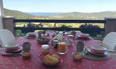 a table with a red table cloth with food on it at A Casa Faggia in Sollacaro