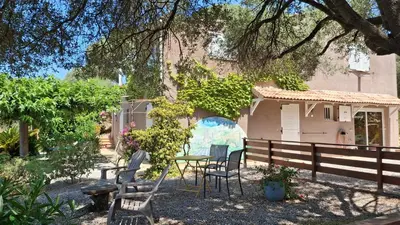 a table and chairs in front of a house at A Casa Faggia in Sollacaro