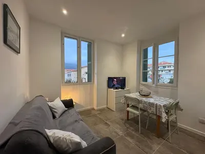 a living room with a couch and a table at Appartement plein centre avec jardin de 40m2 près des plages in Propriano
