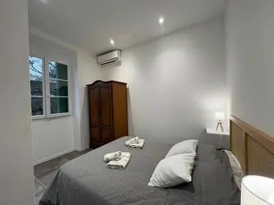a bedroom with a bed with towels on it at Appartement plein centre avec jardin de 40m2 près des plages in Propriano