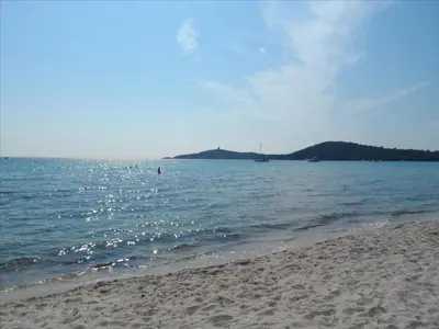 a sandy beach with a view of the ocean at Rez de jardin d'une villa in Zonza