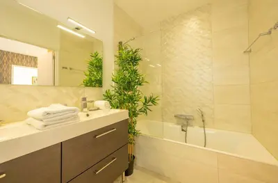 a bathroom with a sink and a tub and a mirror at Villa Suartello Porto Vecchio avec piscine privée in Porto-Vecchio