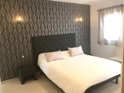 a bedroom with a white bed with a black headboard at Villa Suartello Porto Vecchio avec piscine privée in Porto-Vecchio