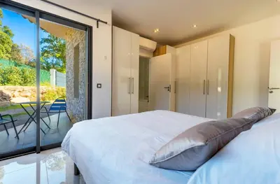 a bedroom with a bed and a large glass window at Villa Suartello Porto Vecchio avec piscine privée in Porto-Vecchio