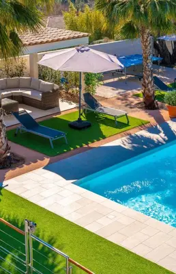 a swimming pool with an umbrella and a couch and an umbrella at Villa Suartello Porto Vecchio avec piscine privée in Porto-Vecchio