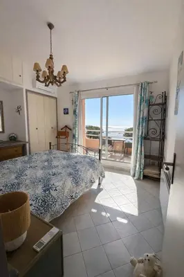a room with a bed and a view of the ocean at Mini Villa Kallisté - vue mer exceptionnelle sur la baie de Palombaggia in Porto-Vecchio