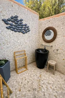a bathroom with a black tub and a mirror at Mini Villa Kallisté - vue mer exceptionnelle sur la baie de Palombaggia in Porto-Vecchio