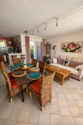 a living room with a table and chairs at Mini Villa Kallisté - vue mer exceptionnelle sur la baie de Palombaggia in Porto-Vecchio