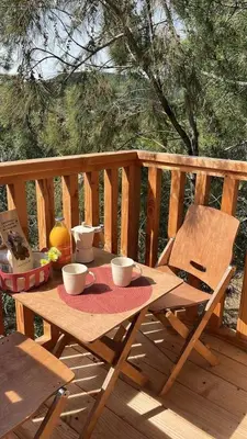 a wooden table on a deck with two coffee cups at Camping 3 étoiles - Piscine - ccbeegd in Porto-Vecchio