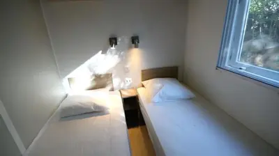 two beds in a room with a window at Camping 3 étoiles - Piscine - ccbeegd in Porto-Vecchio