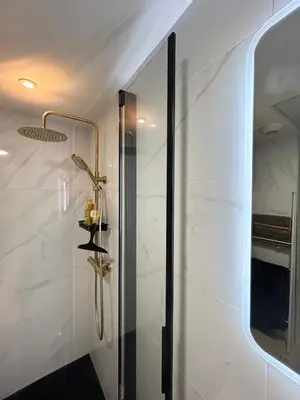 a bathroom with a shower with a glass door at Charmant T2 sur le Port de Plaisance de Solenzara in Sari Solenzara